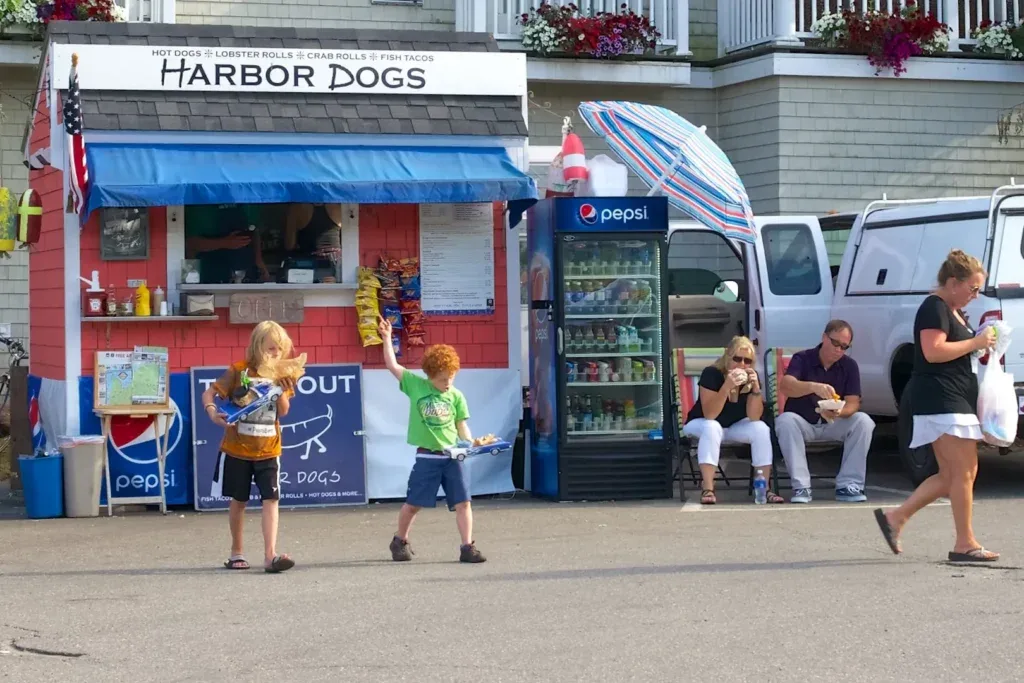 A hot dog food stand and a drinks fridge.  