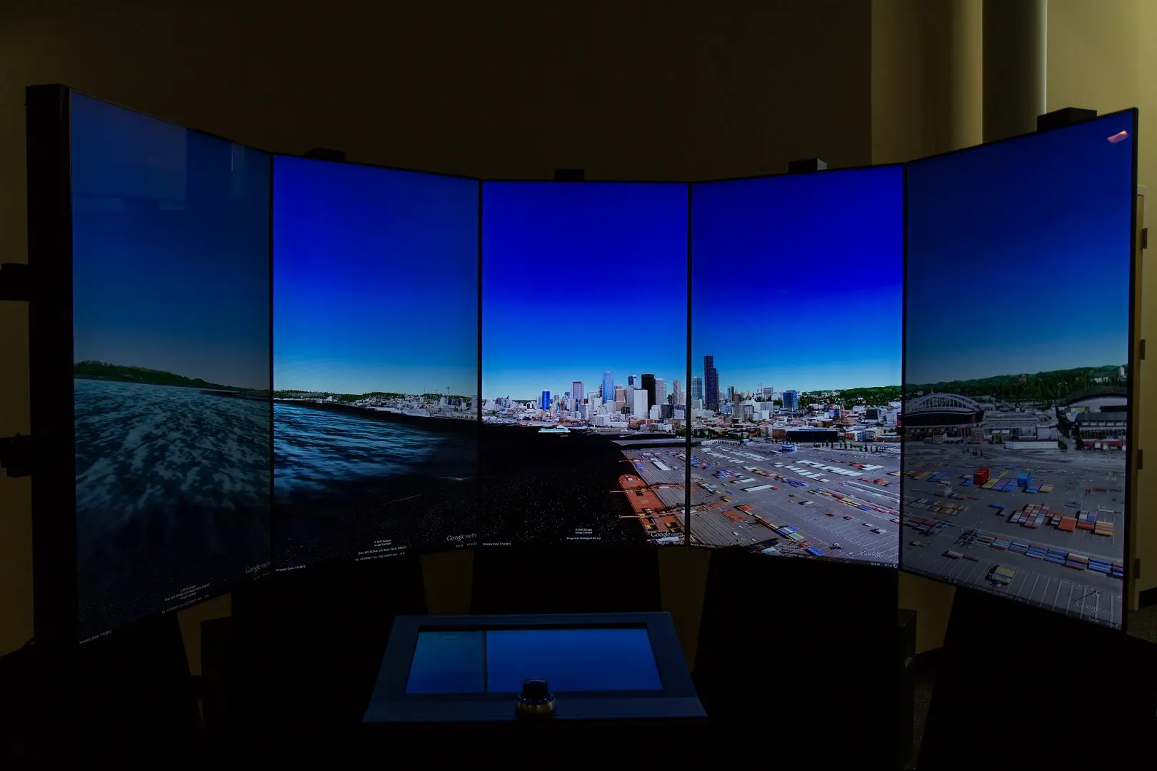 Five display monitors linked in a curved display.