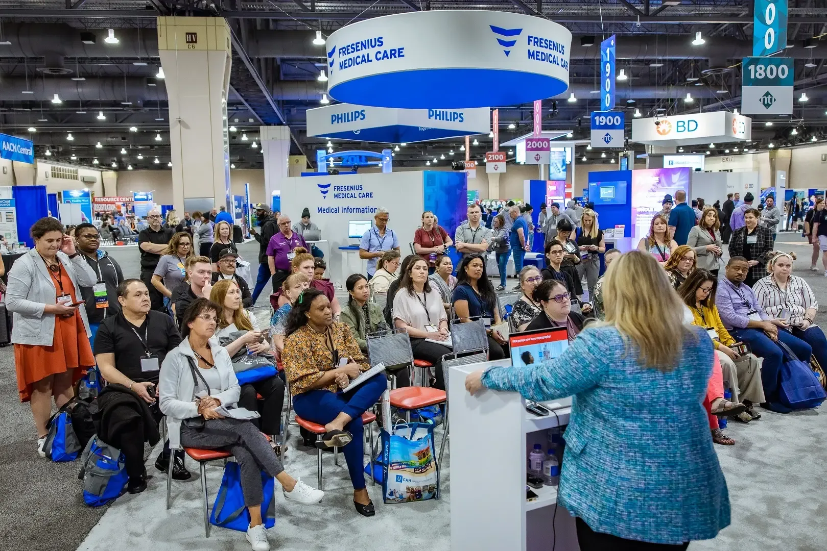A medical professional giving a presentation to a group of people at a trade show.