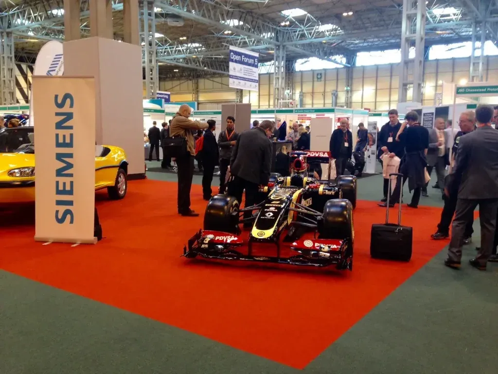A group of trade professionals standing around a Lotus Renault F1 car.
