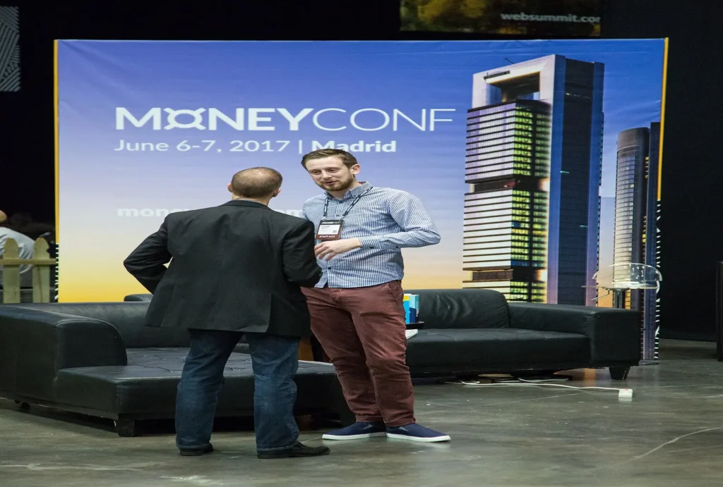 Two business professionals speak on stage at MoneyConf 2017 in Madrid. 