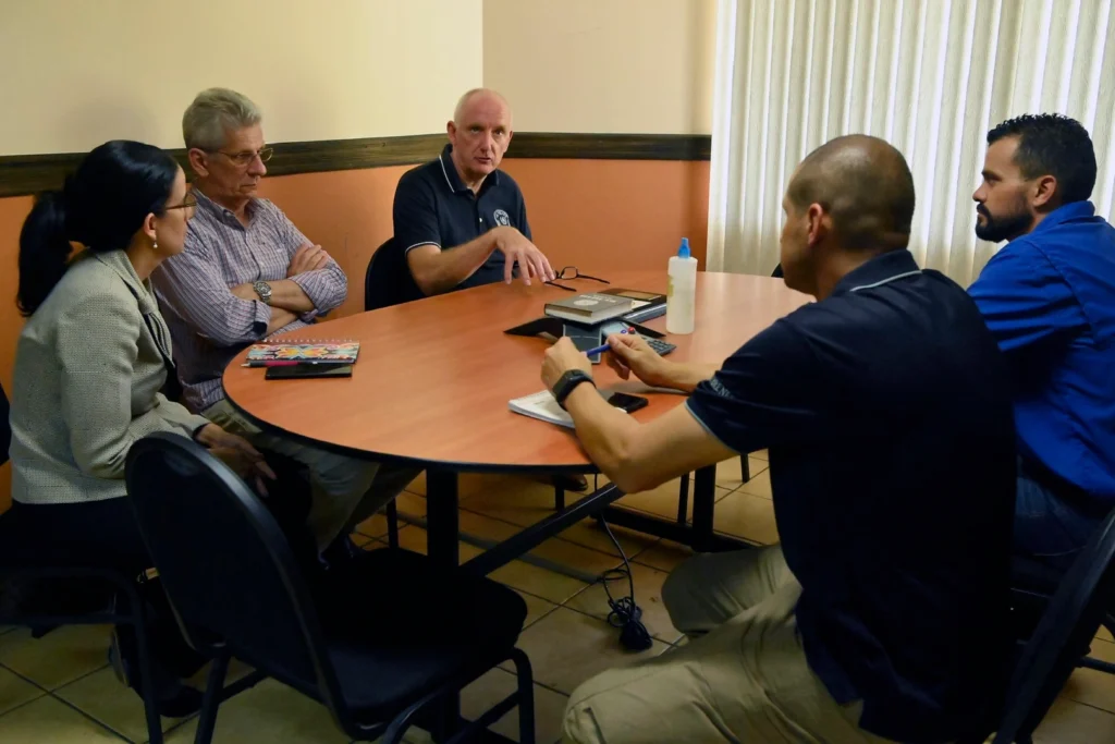 A group of people discuss matters at a table.