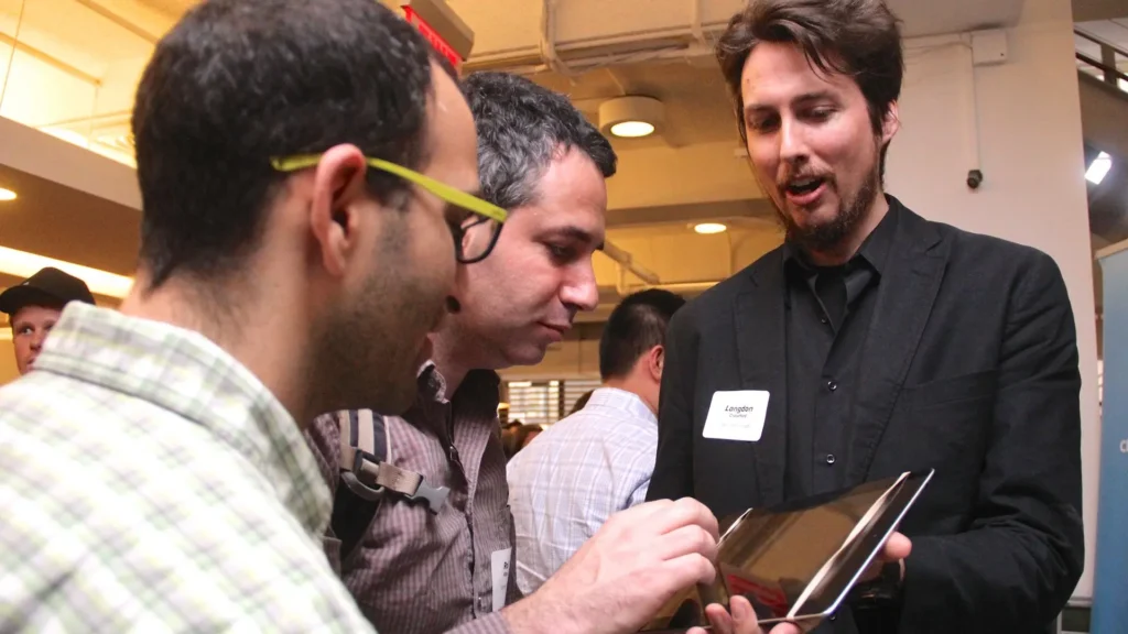 A staff member giving a tech demo on a tablet device at an event.