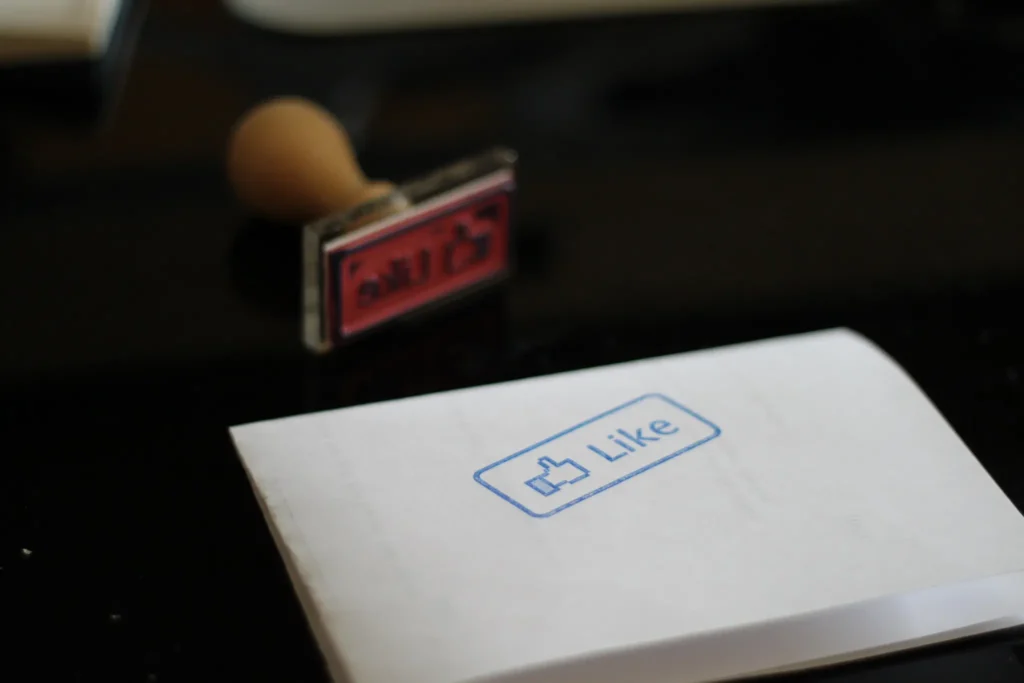 A stamp of the Facebook "like" button in blue ink.