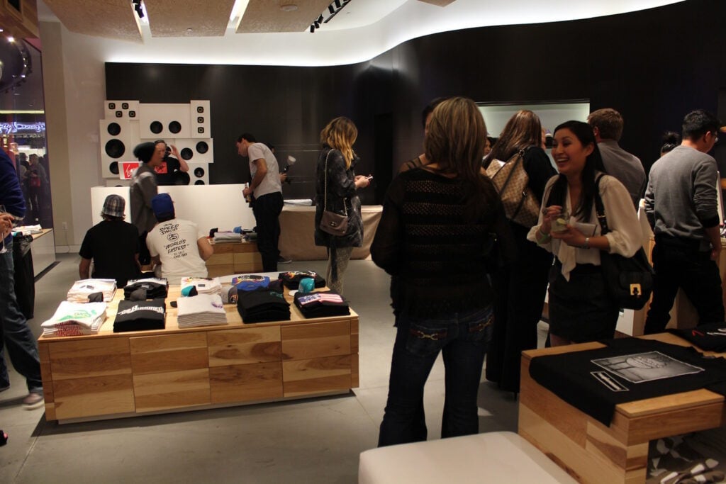 Multiple people examine a clothing pop-up store. 