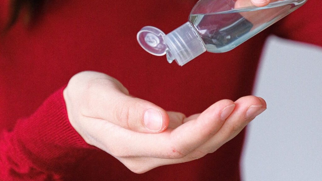 A person pouring hand sanitizer onto their hand.