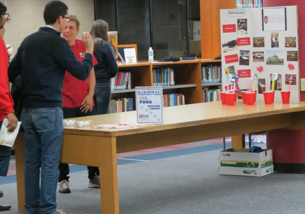 An carnival-style game where a guest has to throw a ping pong ball inside plastic cups.
