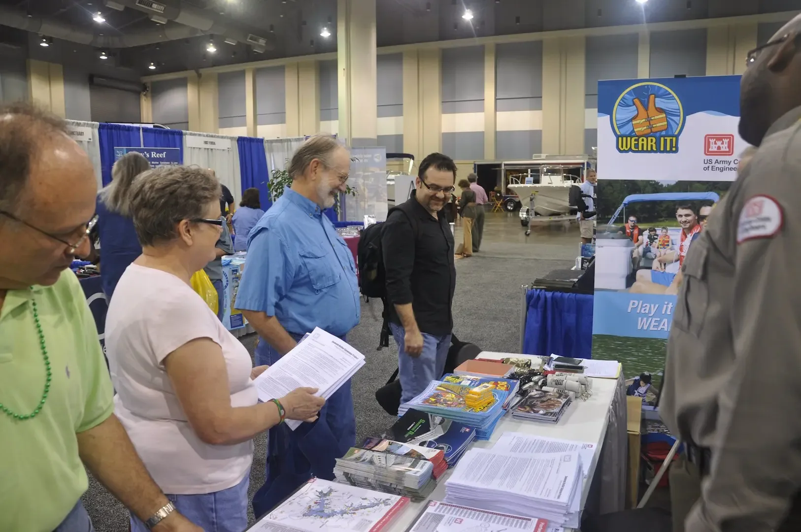 Attendees talk with exhibitors at an outdoor trade show in America.