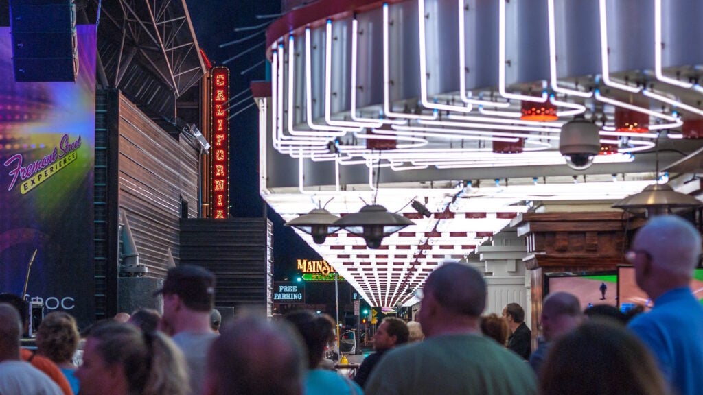 Pedestrians on the sidewalk in Las Vegas at night. 