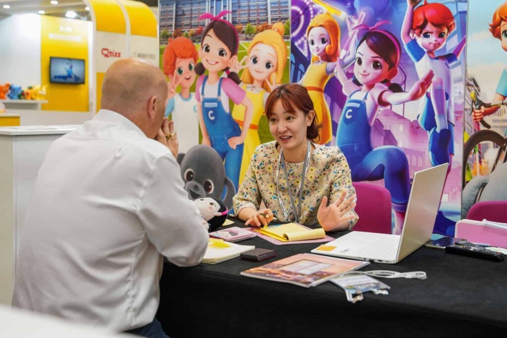 Exhibitor discussing a custom exhibition stand with a visitor at a UK trade show booth