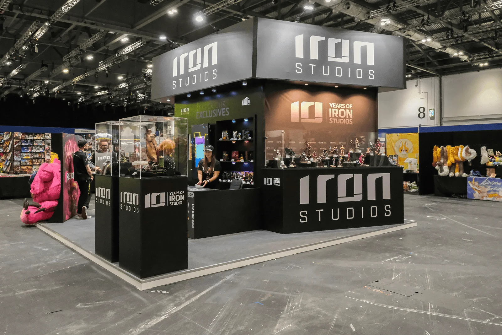 Iron Studios dark retail exhibition stand with collectibles display cases