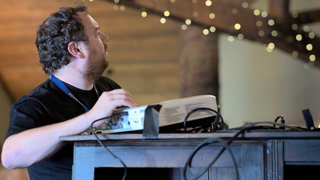 A man setting up audio-visual equipment.