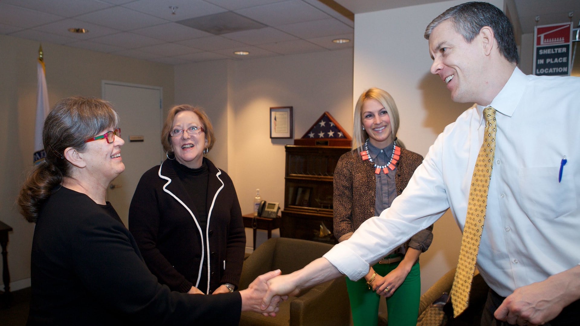 People shaking hands in office setting.